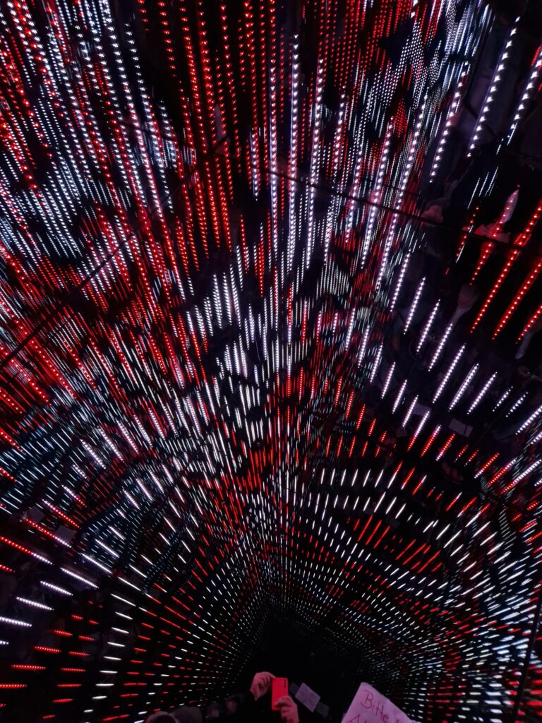 Begehbare LED-Installation im WOW-Museum München mit rot-weißem Lichtmuster an Wänden und Decke